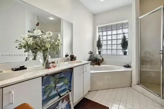 a bathroom with a bathtub double sink and mirror