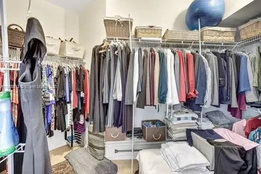 a view of walk in closet with clothes