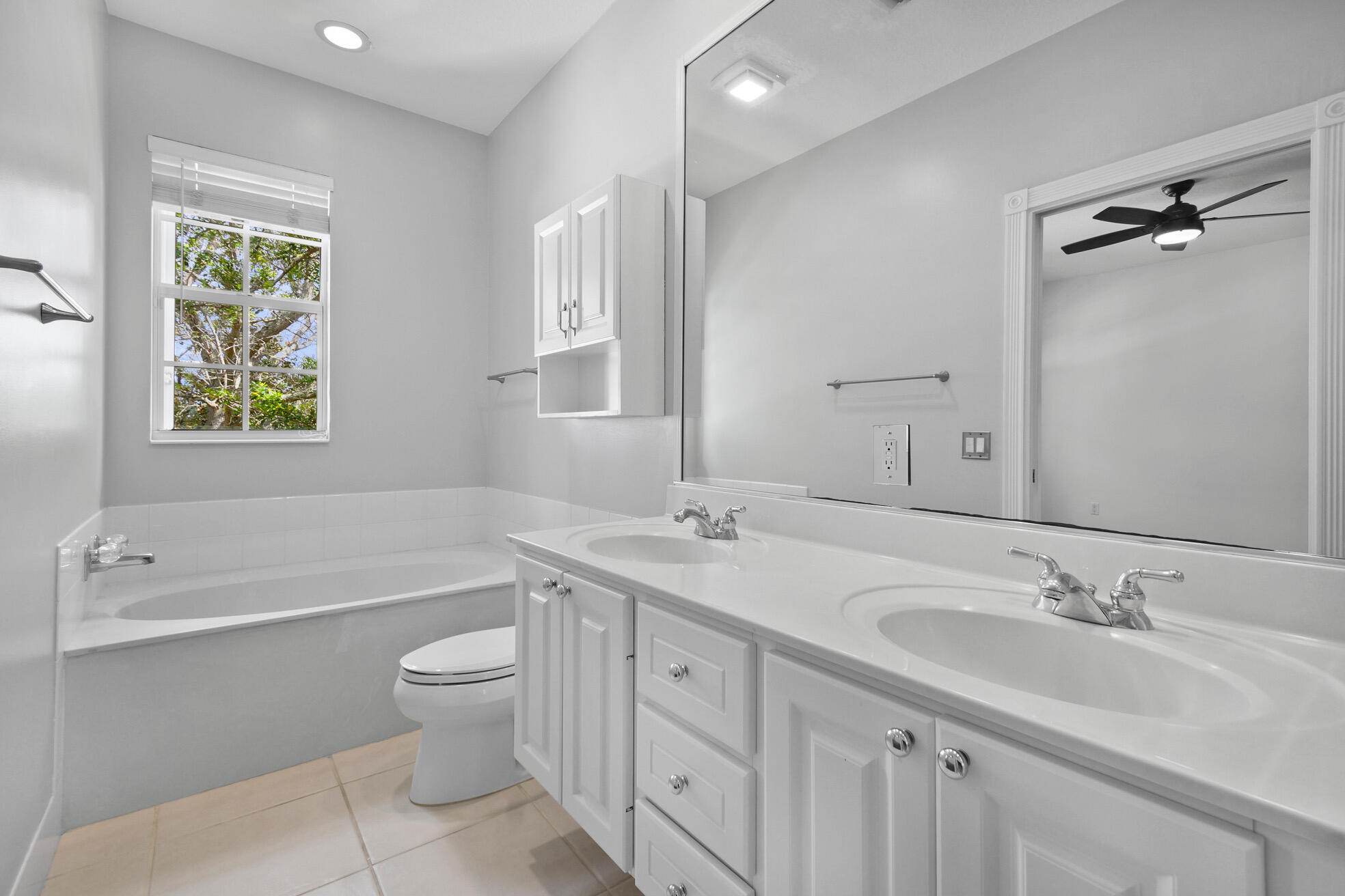 1836 Jeaga Drive Jupiter, FL 33458 - Photo 13 of 25 a bathroom with a double vanity sink a toilet and a bathtub