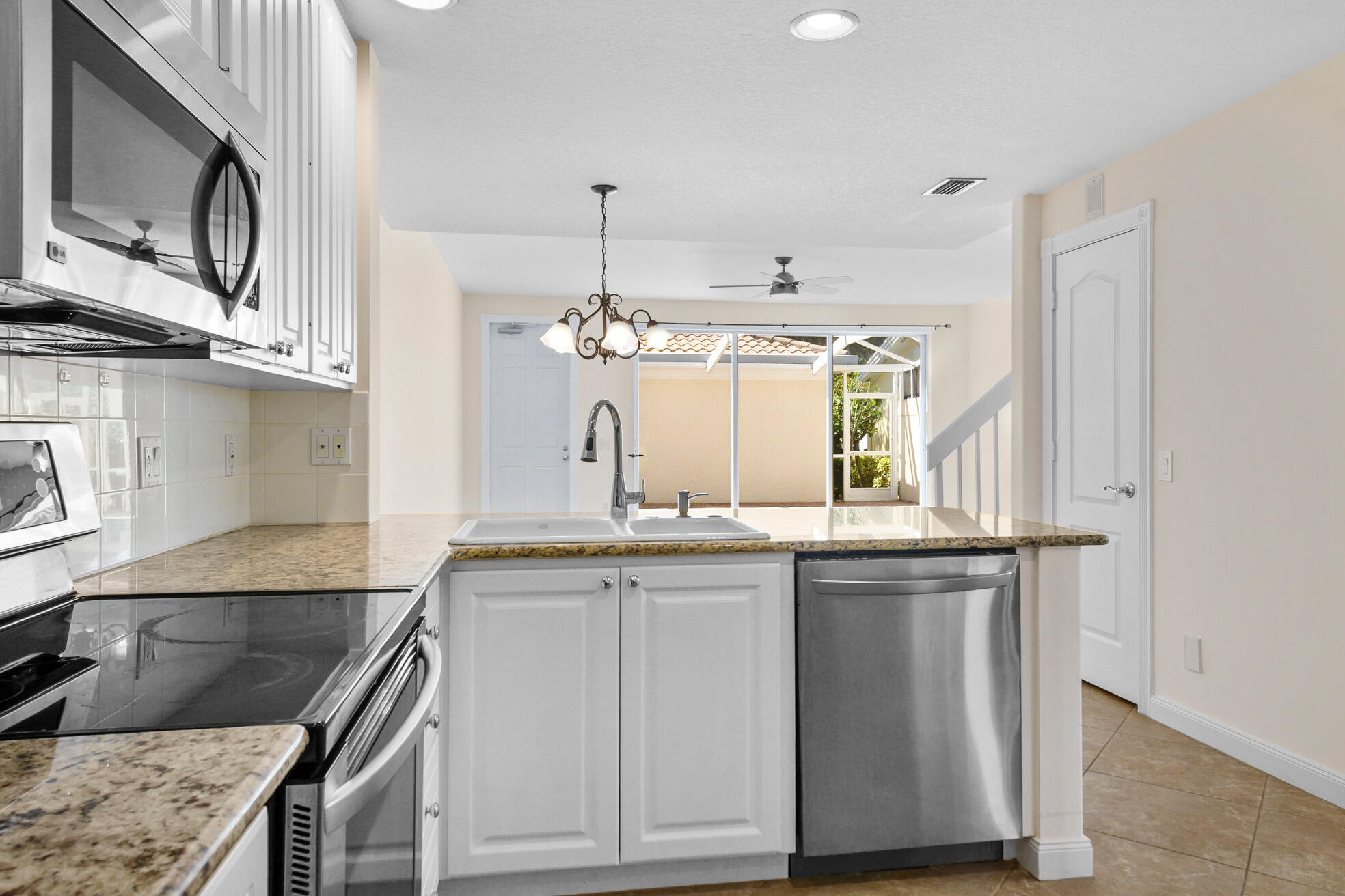 1836 Jeaga Drive Jupiter, FL 33458 - Photo 2 of 25 a kitchen with stainless steel appliances granite countertop a sink and stove