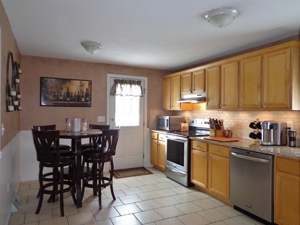 22 Pheasant Drive Springfield, MA 01119 - Photo 3 of 28 a kitchen with stainless steel appliances granite countertop a stove a sink a dining table and chairs