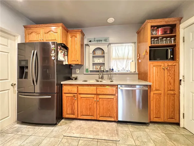a kitchen with stainless steel appliances granite countertop a refrigerator a sink a stove and island