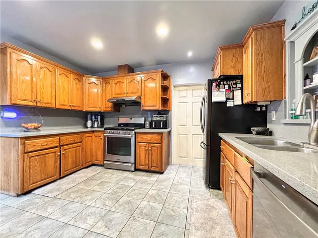 a kitchen with a sink stove top oven and refrigerator