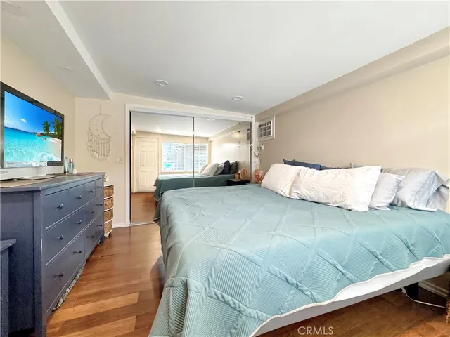 a bedroom with a large bed and a flat tv screen on dresser
