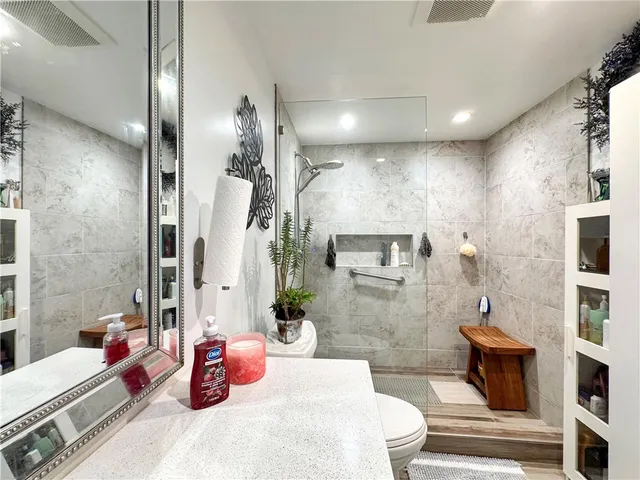 a bathroom with a sink a toilet and shower