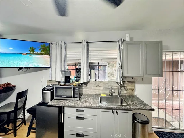 a kitchen with stainless steel appliances granite countertop a sink a stove and a wooden cabinets