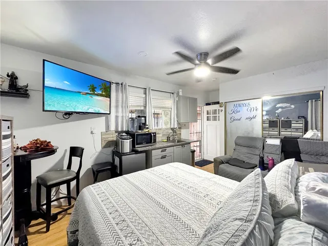 a bedroom with furniture a bed and a flat screen tv