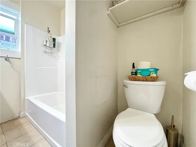 a white toilet sitting next to a white tub