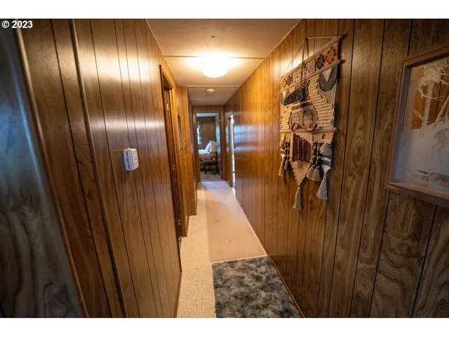 a bedroom with a bed and a dresser with wooden walls