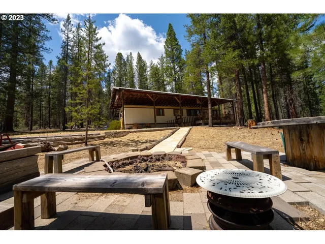 a view of a backyard with table and chairs with wooden fence