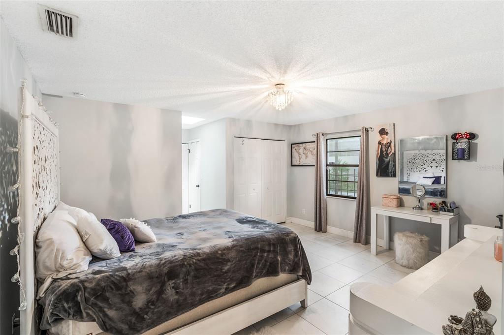 1760 12th Street Clermont, FL 34711 - Photo 15 of 42 a bedroom with a large bed couch and a window