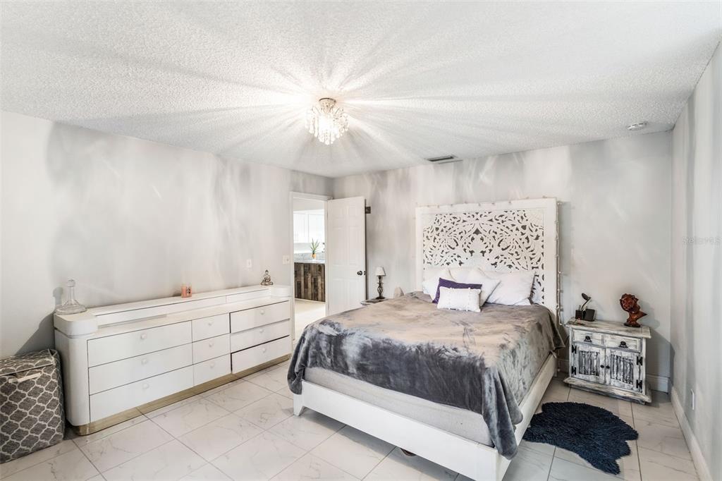 1760 12th Street Clermont, FL 34711 - Photo 16 of 42 a bedroom with a bed and a chandelier