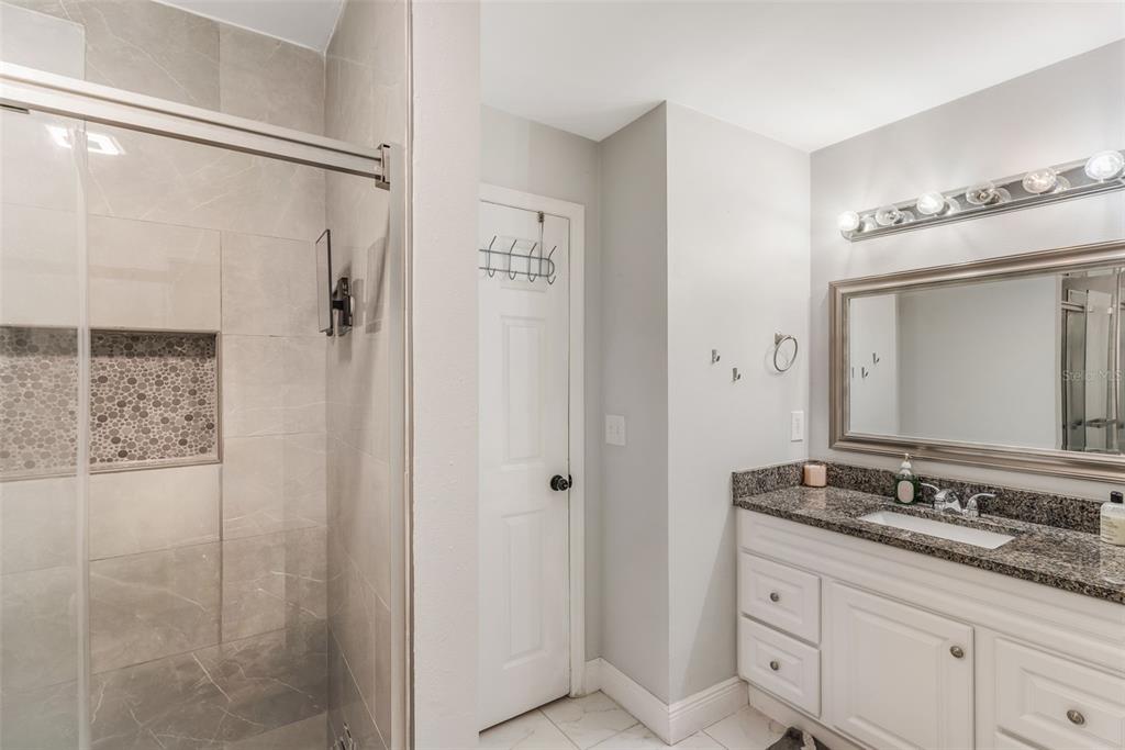 1760 12th Street Clermont, FL 34711 - Photo 18 of 42 a bathroom with a granite countertop shower sink and mirror