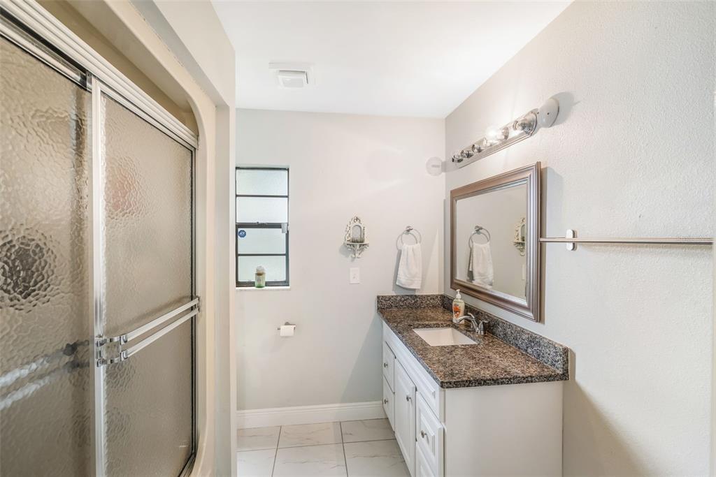 1760 12th Street Clermont, FL 34711 - Photo 21 of 42 a bathroom with a granite countertop sink and a mirror