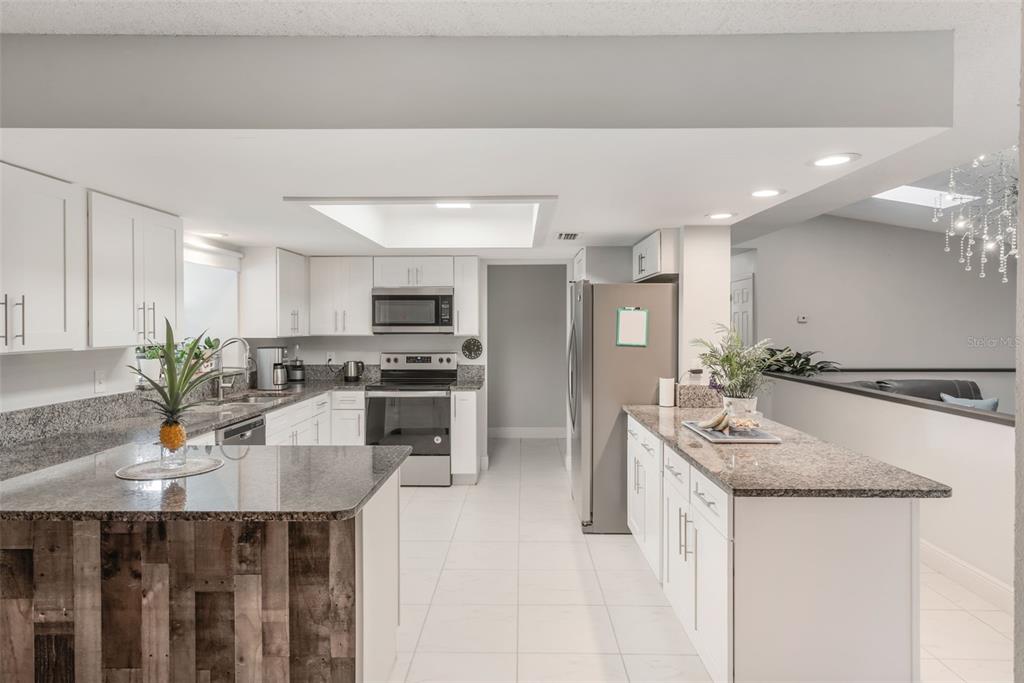 1760 12th Street Clermont, FL 34711 - Photo 10 of 42 a kitchen with kitchen island granite countertop a sink a counter top space and stainless steel appliances