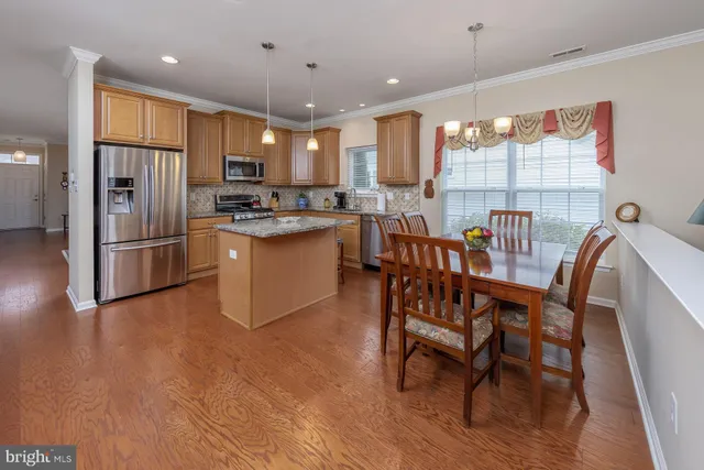 a kitchen with a table chairs refrigerator and microwave