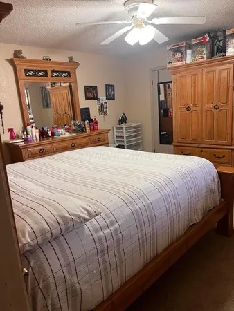 a large bed sitting in a bedroom and a chandelier