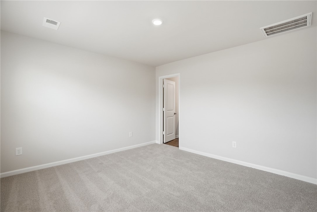 305 Lilac Loop Greenwood, SC 29646 - Photo 19 of 25 A spacious, newly carpeted room awaits personalization, perfect for a peaceful retreat.