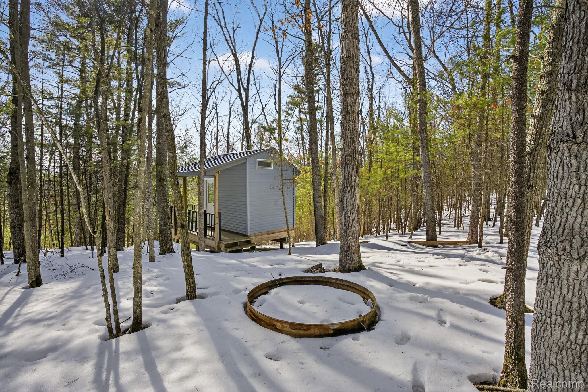 101 Highview Road Traverse City, MI 49696 - Photo 73 of 88 Yard layered in snow with an outbuilding and view of scattered trees