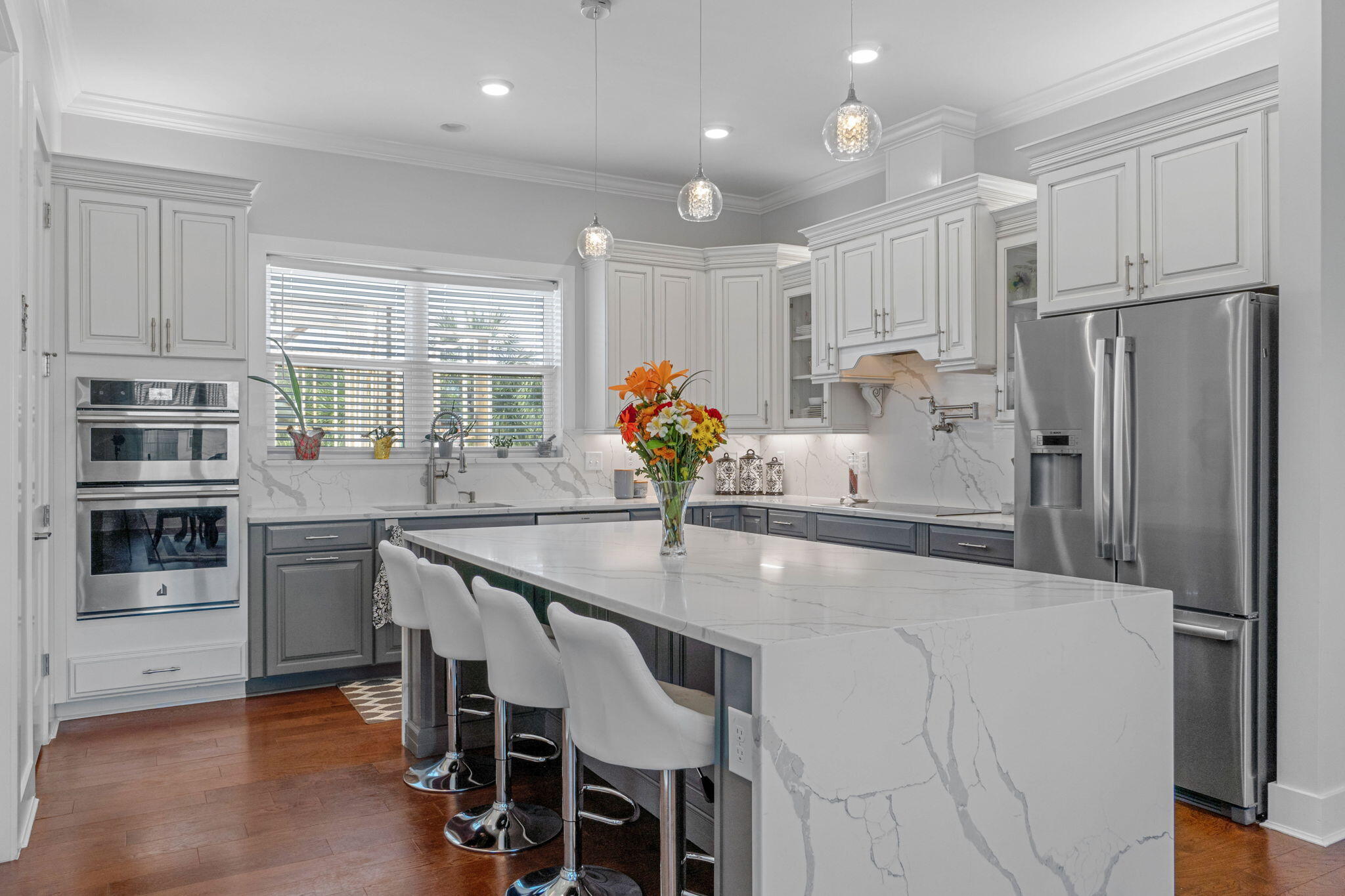 234 Inverrary Drive Destin, FL 32541 - Photo 15 of 53 a kitchen with stainless steel appliances granite countertop a refrigerator a sink dishwasher a stove and a dining table with wooden floor