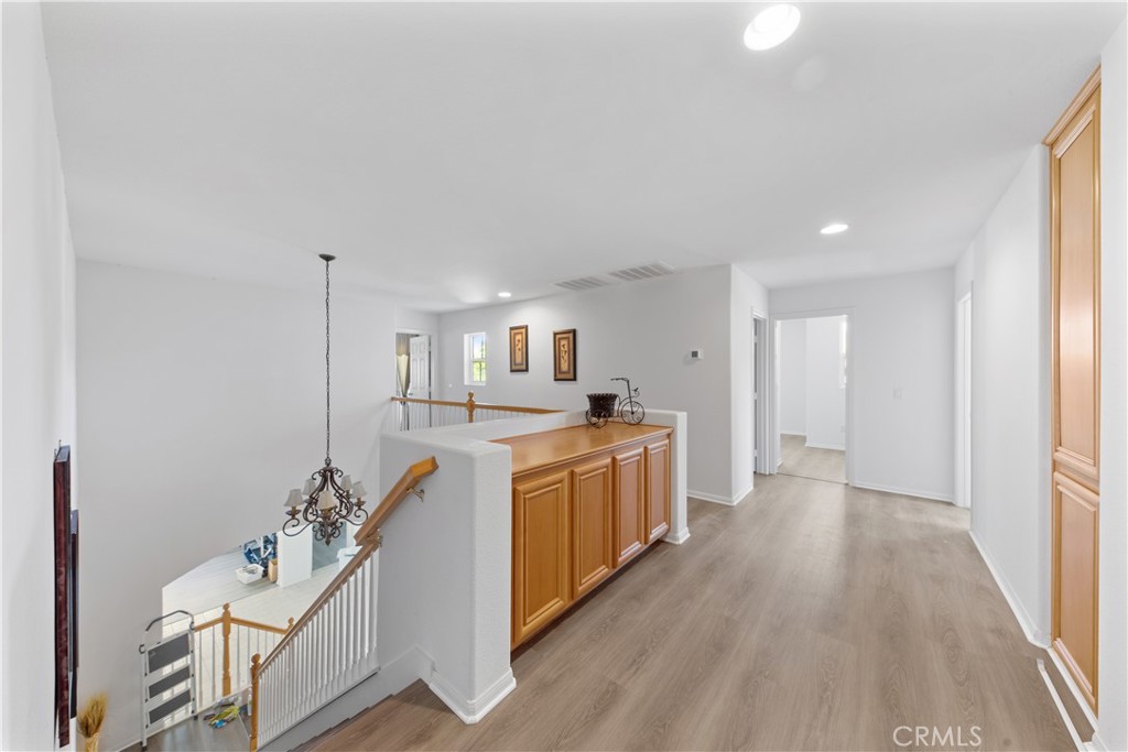 34138 Amici Street Temecula, CA 92592 - Photo 18 of 45 a kitchen with stainless steel appliances kitchen island wooden floors and white cabinets