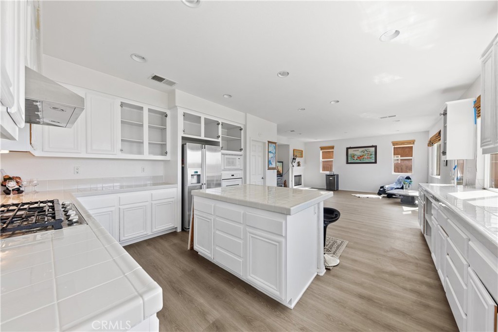 34138 Amici Street Temecula, CA 92592 - Photo 2 of 45 a view of a kitchen with kitchen island a sink wooden floor and counter top space