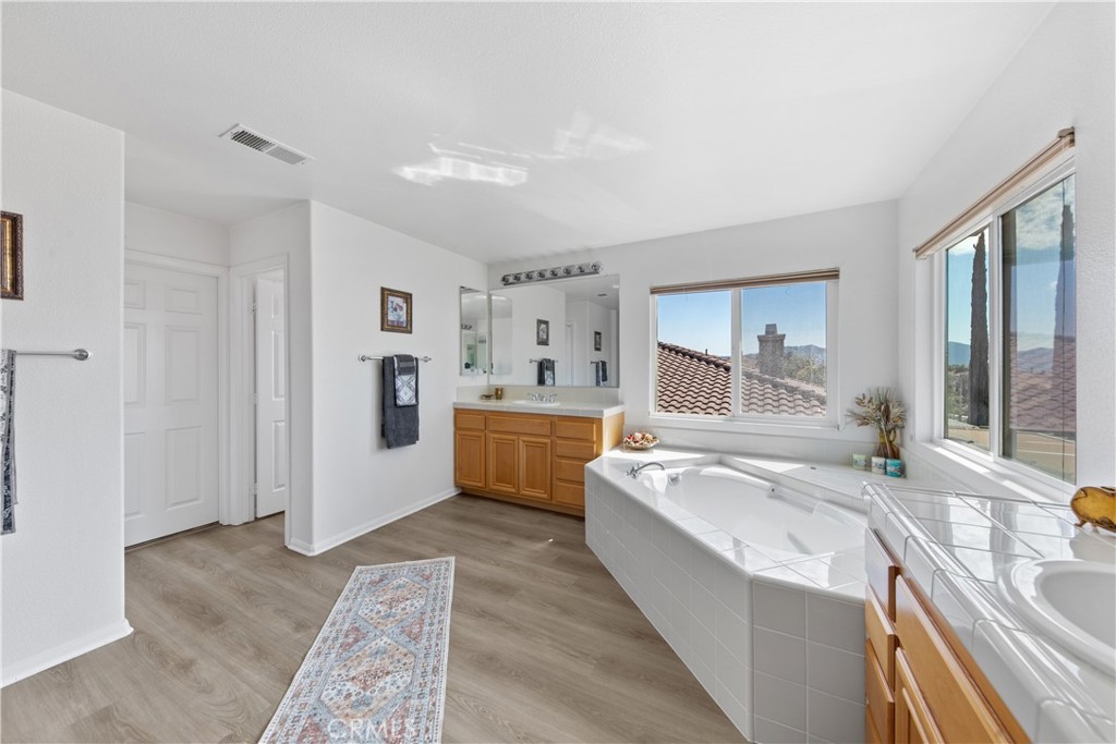 34138 Amici Street Temecula, CA 92592 - Photo 23 of 45 a large bathroom with a tub a sink and mirror