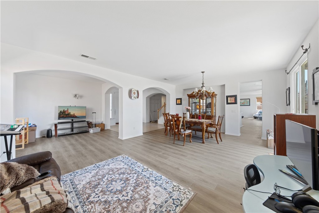 34138 Amici Street Temecula, CA 92592 - Photo 5 of 45 a living room with furniture and a dining table with wooden floor