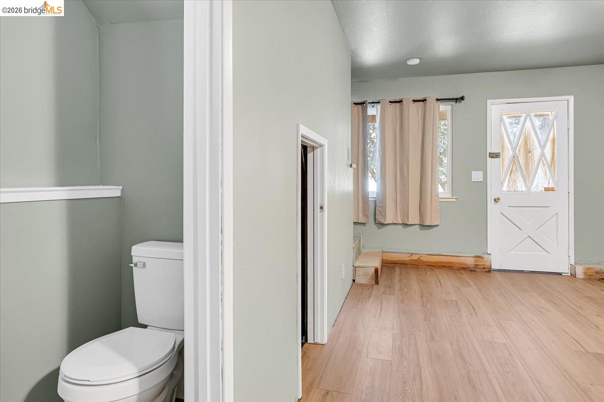 8733 Fraguero Road Sonora, CA 95370 - Photo 55 of 73 Light wood-finish flooring provides a bright base to this space featuring a paneled door with a diamond-patterned window, complemented by a window with a curtain rod