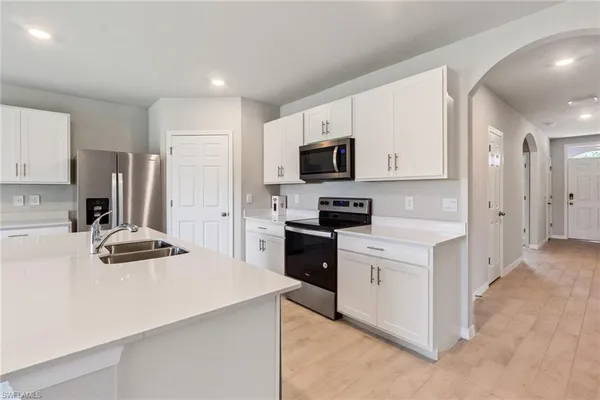 a kitchen with kitchen island a refrigerator stove and microwave