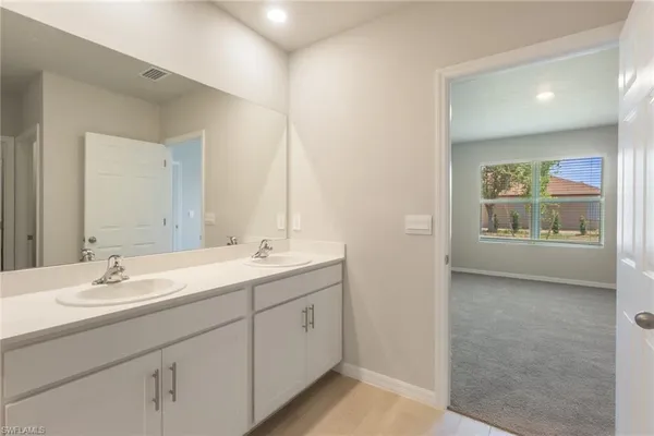 a bathroom with a double vanity sink toilet mirror and shower