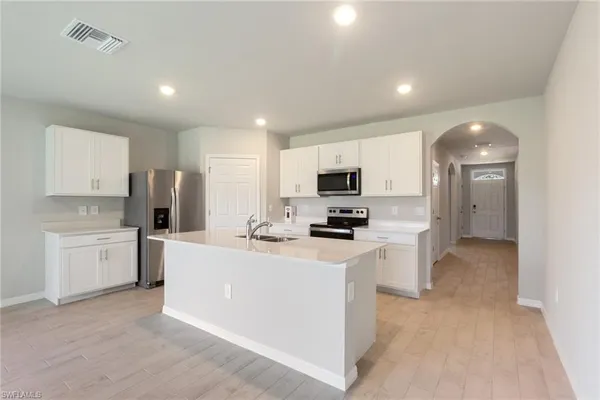a kitchen with white cabinets and stainless steel appliances