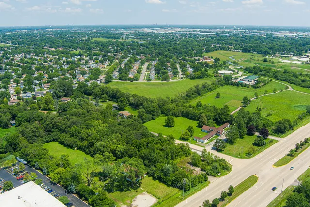 an aerial view of residential houses with outdoor space and trees