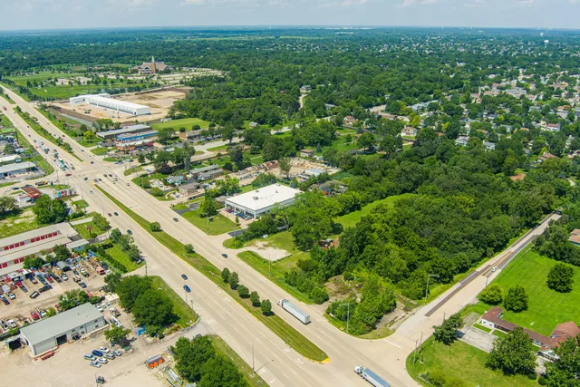 an aerial view of residential houses with outdoor space and trees