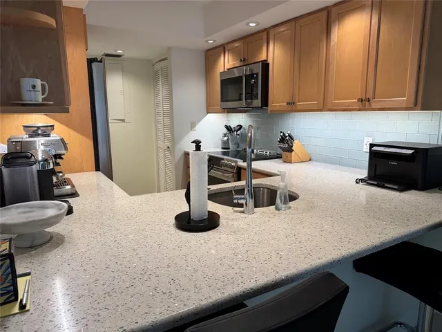 a kitchen with a sink a stove and chairs