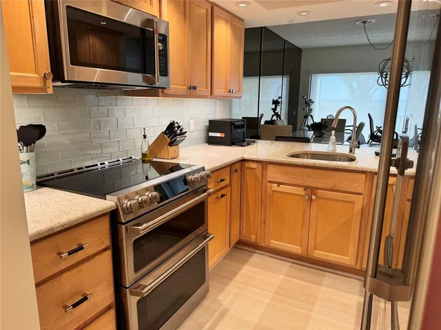 a kitchen with a sink a stove and cabinets