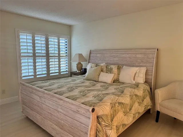 a bed sitting in a bedroom next to a window