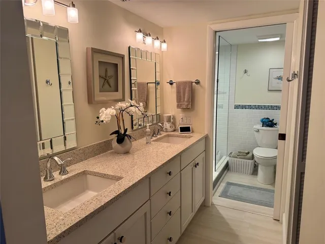 a bathroom with a double vanity sink a mirror and a shower