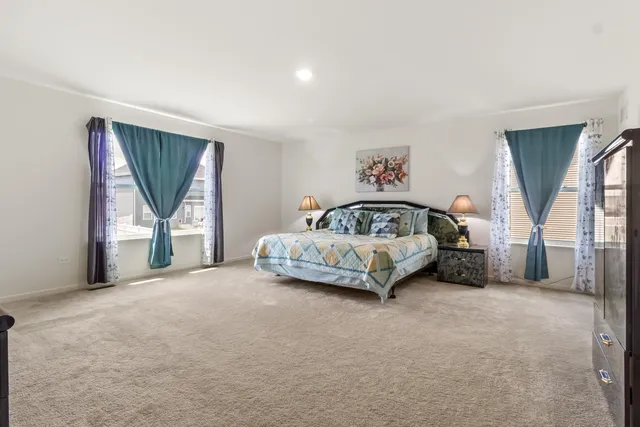 a spacious bedroom with a bed and a cabinets