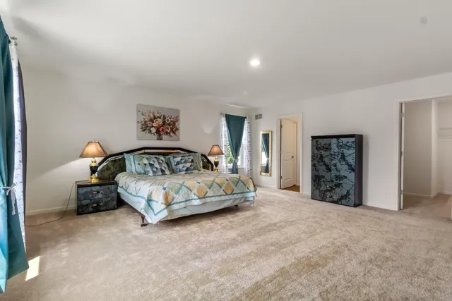 a bedroom with a large bed and a window