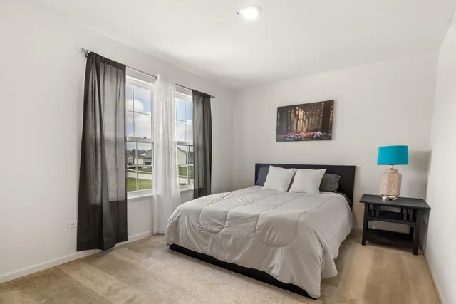 a bedroom with a bed and a large window