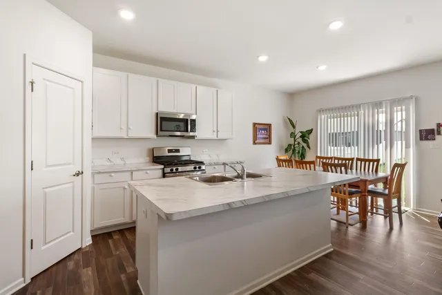 a kitchen with a sink a microwave and wooden floor