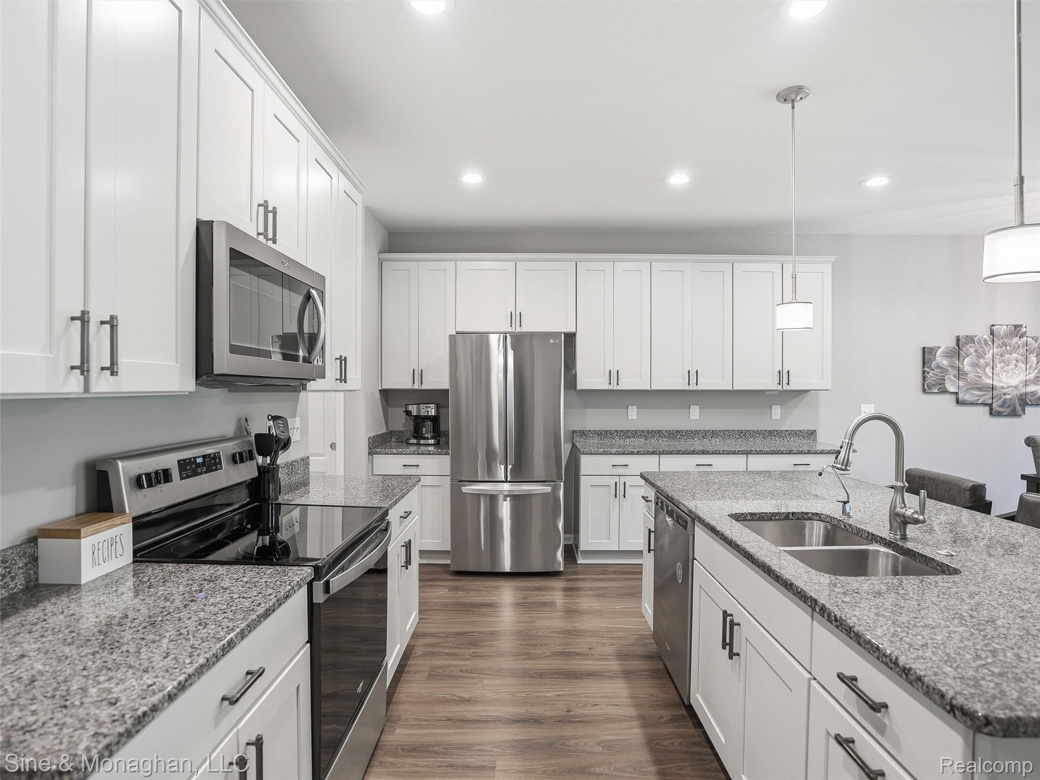 24827 Ivy Road Novi, MI 48375 - Photo 6 of 38 Contemporary kitchen featuring white cabinetry, stainless steel appliances, granite countertops, and wood-finish flooring