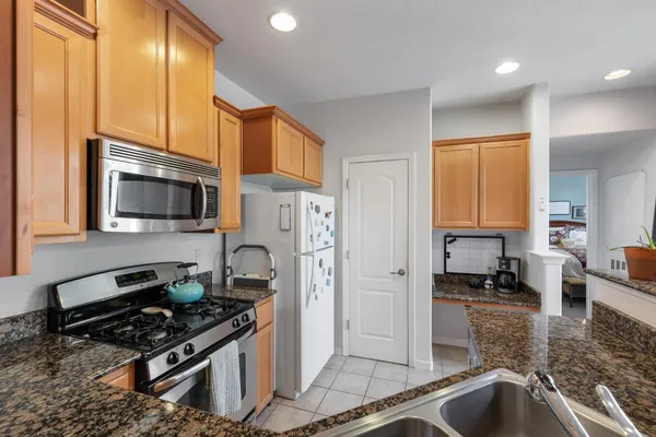 a kitchen with stainless steel appliances granite countertop a sink stove and refrigerator