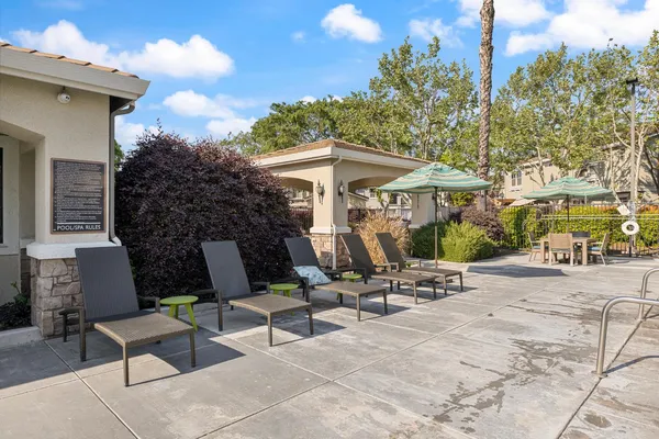 a view of a patio with a table and chairs under an umbrella