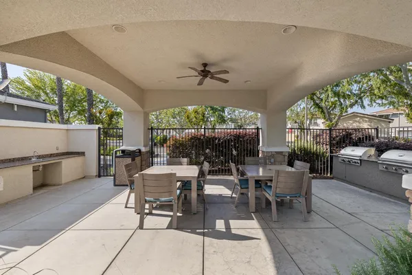 a outdoor space with lots of tables a chairs and potted plants