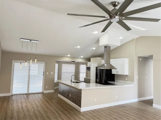 a view of kitchen with kitchen island stainless steel appliances sink and wooden floor