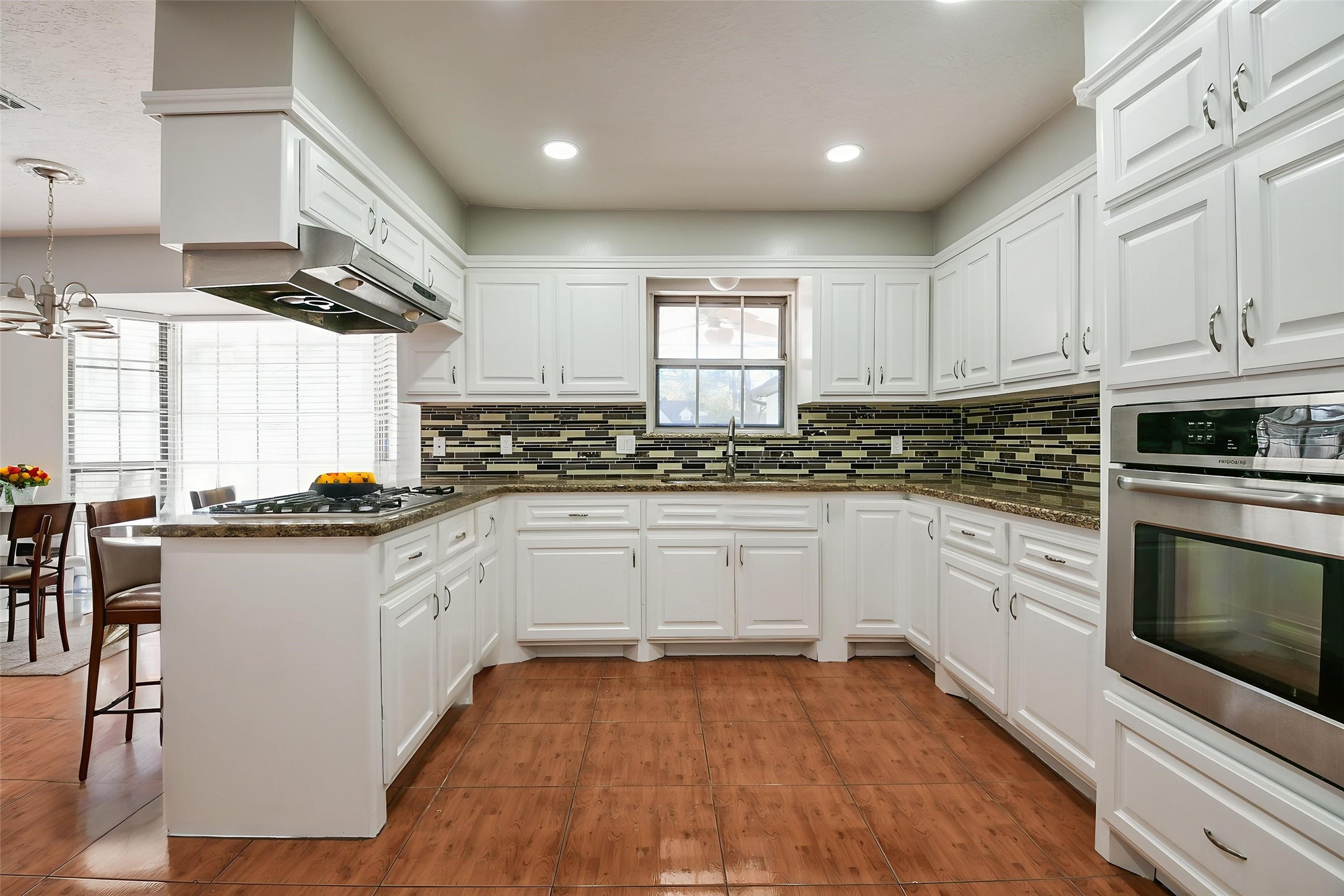 1007 Maranon Lane Houston, TX 77090 - Photo 17 of 36 The newly renovated kitchen features modern granite countertops and tile backsplash inserts, adding a contemporary flair to the space.