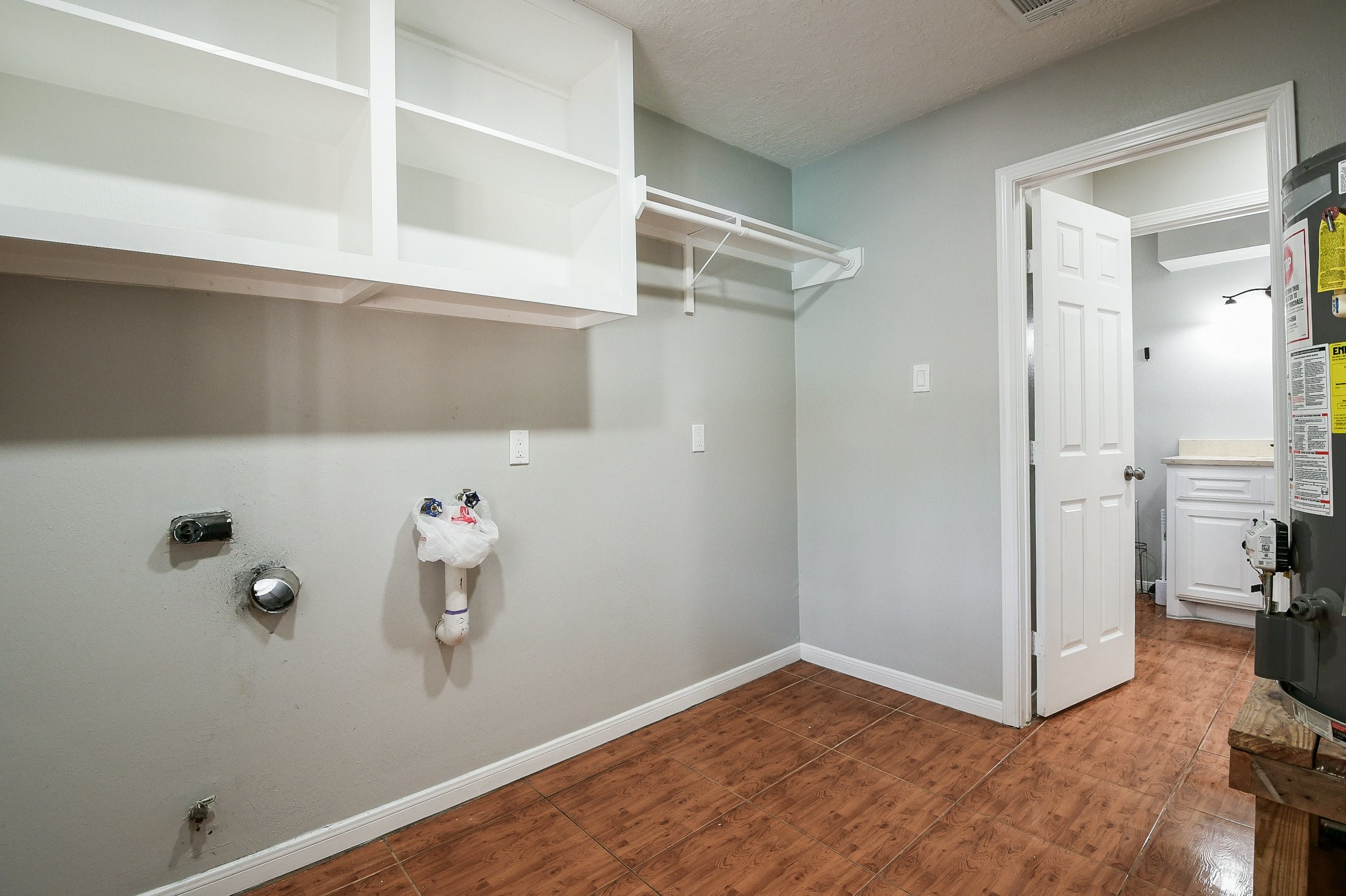 1007 Maranon Lane Houston, TX 77090 - Photo 30 of 36 The utility room is located inside the house and features a dryer that can be powered by gas, offering you the option for added savings on your utility bills. Additionally, the picture shows your 7-year gas water heater.