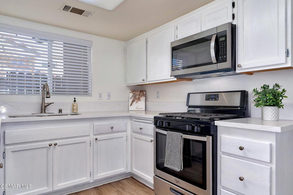 4508 Apricot Road, Unit B Simi Valley, CA 93063 - Photo 14 of 44 a kitchen with stainless steel appliances granite countertop white cabinets a stove a sink and dishwasher